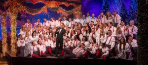 group of performers on stage smiling