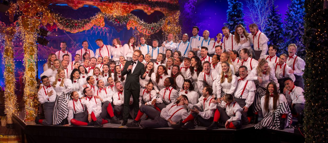 group of performers on stage smiling